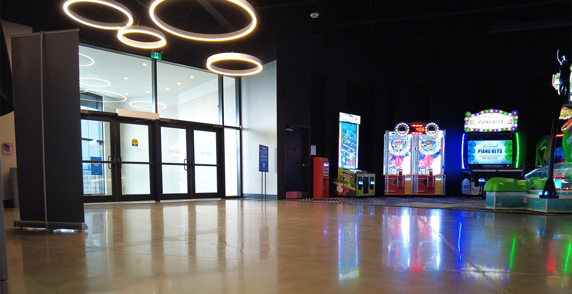 Cineplex interior entrance, polished concrete floors and arcade games in background.